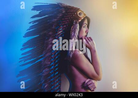Belle jeune brunette avec de grands American Indian panache de plumes brunes. a de longs cheveux noirs Banque D'Images