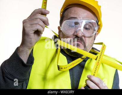 Prise de mesure avec un mètre, un homme qui veut faire un travail sans connaissance, sans expérience de travail. Faire vous-même, l'homme d Banque D'Images