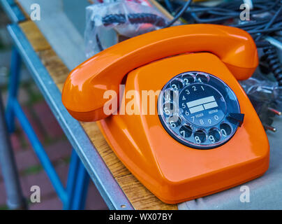 Crissement laid vieux couleur orange mécanique téléphone analogique avec cadran noir et blanc pavé numérique Banque D'Images