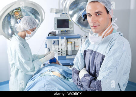 Portrait de femme chirurgien alors que l'application de l'infirmière au patient masque à gaz Banque D'Images