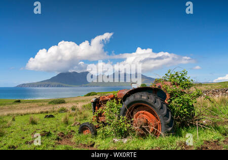 Un tracteur abandonné sur un Cleadale Croft, avec vue lointaine de l'île de rhum en milieu de l'été, Cleadale, île de Eigg, Hébrides intérieures, Ecosse, Royaume-Uni Banque D'Images