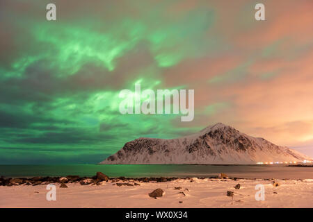 Les aurores boréales avec montagnes en hiver, Reine, les îles Lofoten, Nordland, Norvège, Europe, de l'Arctique Banque D'Images