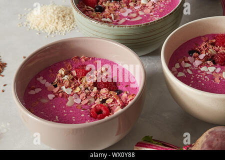 Petit-déjeuner sain smoothie rouge surmontée de bols de fruits, noix et baies Banque D'Images