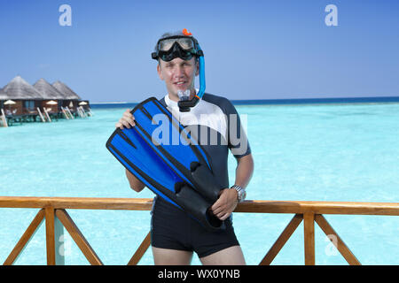 Jeune homme sportif avec palmes, masque et tube près de la mer. Les Maldives. Banque D'Images
