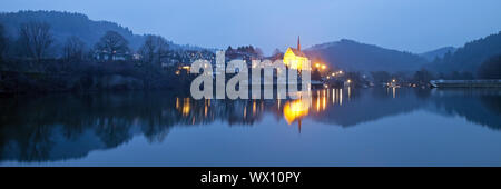 Beyenburg storage lake et illuminé l'église St Mary Magdalena dans la soirée, Wuppertal Banque D'Images