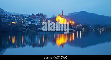 Beyenburg storage lake et illuminé l'église St Mary Magdalena dans la soirée, Wuppertal Banque D'Images