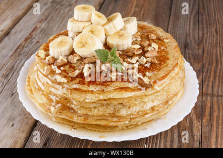 Pile, crêpes, crêpes, miel, banane, noix, petit-déjeuner sain, Maslennitsa, crêpes russes. Banque D'Images