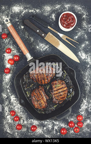 Des steaks grillés, des grillades, steak, boeuf, balsamique, romarin, table en pierre, tomates cerises, ketchup, haut Banque D'Images