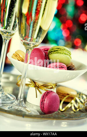 Macarons colorés et Champagne sur fond d'arbre de Noël Banque D'Images