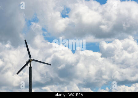 La production d'électricité éolienne contre ciel nuageux ciel bleu Banque D'Images