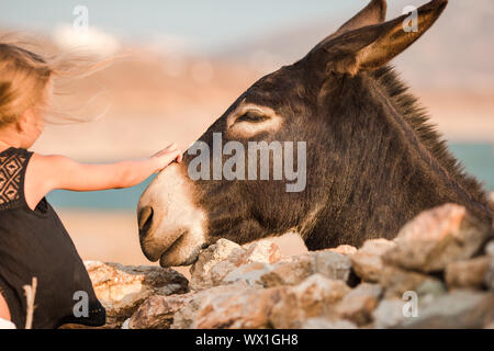 Petite fille avec un âne sur l'île grecque Banque D'Images