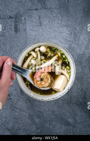 La soupe miso traditionnelle japonaise avec des langoustines et le tofu en vue de dessus dans un bol avec copie espace Banque D'Images