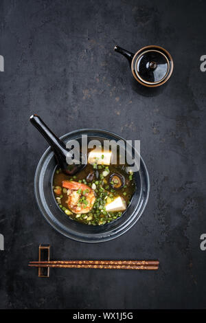 La soupe miso traditionnelle japonaise avec des langoustines et le tofu en vue de dessus dans un bol avec copie espace Banque D'Images