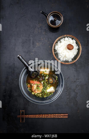 La soupe miso traditionnelle japonaise avec des grosses crevettes et riz en tant que vue de dessus dans un bol avec copie espace Banque D'Images