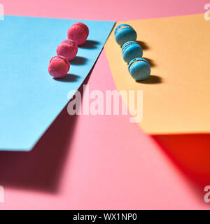 Macarons différents présentés dans une rangée sur un fond de papier de couleur Banque D'Images