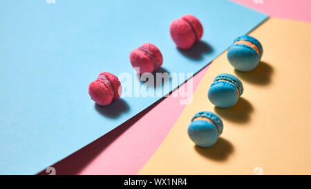 La composition créative avec macarons bleu et rose sur un fond de papier multicolores Banque D'Images