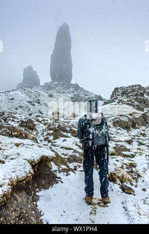 Une approche walker le vieil homme de Storr pinnacle rock dans une forte averse de neige. Le Storr, Trotternish, Isle of Skye, Scotland, UK Banque D'Images