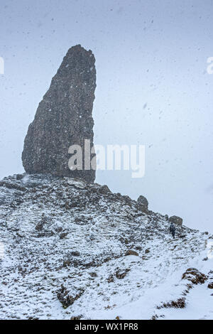 Une approche walker le vieil homme de Storr pinnacle rock dans une forte averse de neige. Le Storr, Trotternish, Isle of Skye, Scotland, UK Banque D'Images