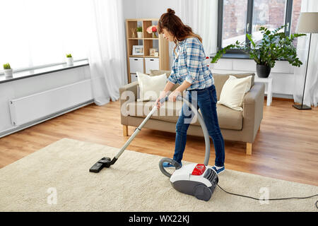 Femme Asiatique avec aspirateur à la maison Banque D'Images