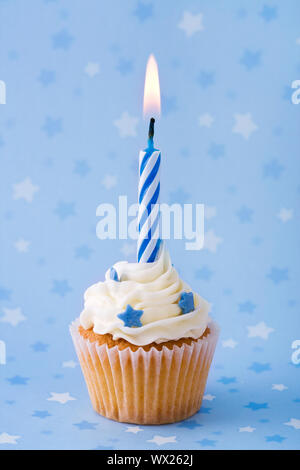 Mini birthday cupcake contre un fond étoilé bleu Banque D'Images