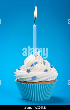 Cupcake avec une seule bougie bleu, décoré avec des étoiles de sucre Banque D'Images