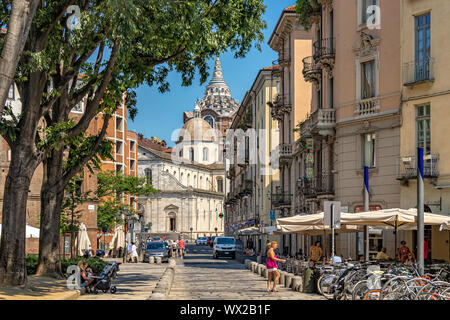 Une vue le long des rues pavées de Largo IV Marzo , avec le dôme de la chapelle baroque Cappella della Sacra Sindone dans la distance, Turin, Italie Banque D'Images