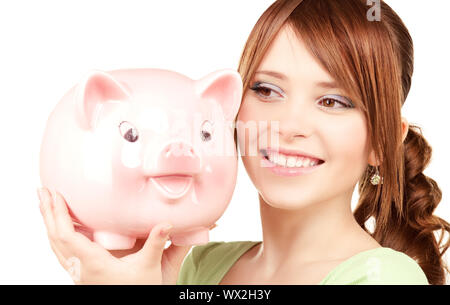 Photo de belle teenage girl with piggy bank Banque D'Images