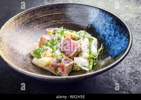 Tataki de thon poêlé moderne salade de filet avec du sucre d'asperges blanches s'enclenche et parmesan en vue de dessus sur une plaque Banque D'Images