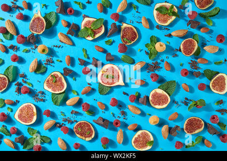 Motif de dessert sucré ripr figues, noix, chocolat, feuille de framboise fraîche, voulait dire sur un fond bleu. Mise à plat Banque D'Images