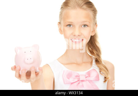 Photo de belle teenage girl with piggy bank Banque D'Images