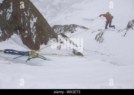 D'alpiniste en rappel dans le mauvais temps Banque D'Images