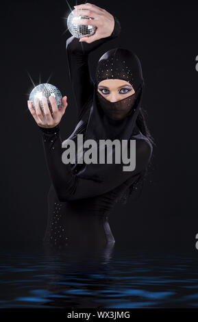 Partie danseur dans ninja dress avec boules disco Banque D'Images