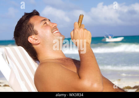 Photo de l'homme décontracté avec cigare sur la plage Banque D'Images