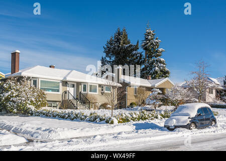 Maison d'habitation couverte de neige avec voiture dans la neige sur la route Banque D'Images