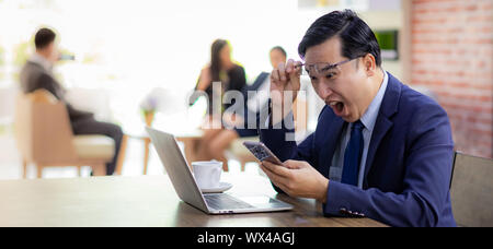 Asian Businessman célébrer dans cafe Banque D'Images