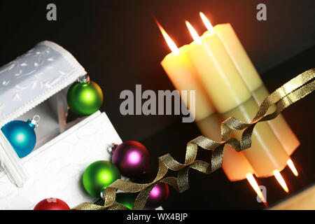 Décorations de Noël, ornements et brûler des bougies sur une surface réfléchissante . L'accent sur ruban. Shallow DOF. Banque D'Images