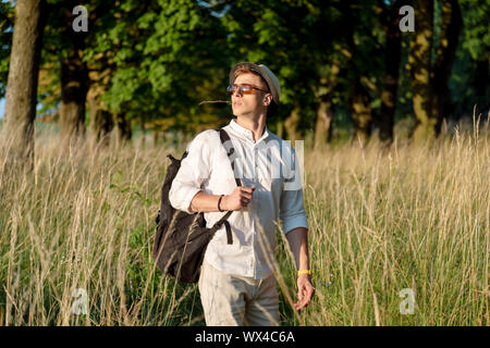 Jeune voyageur guy a est sorti de la forêt et s'amuse de voir un beau coucher de soleil Banque D'Images