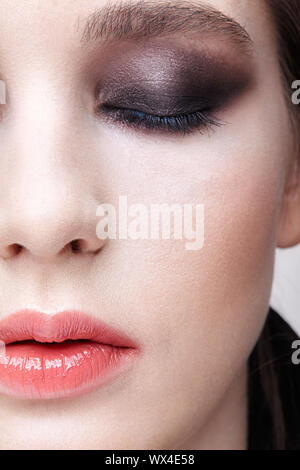 Closeup macro portrait de visage de femme. Fille avec une peau parfaite et violet - noir Smoky Eyes make-up. Banque D'Images