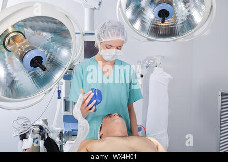 Médecin d'appliquer un masque à oxygène sur le patient avant l'opération Banque D'Images
