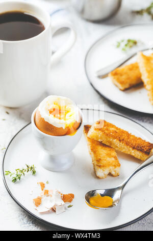 Soft oeuf dur pour le petit-déjeuner avec des toasts et du café tasse en arrière-plan Banque D'Images