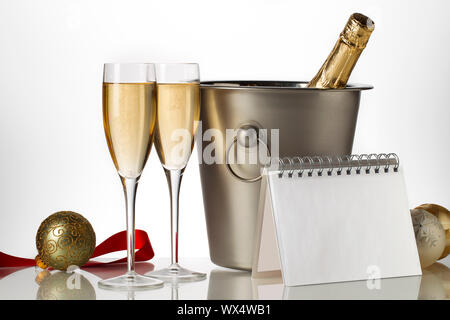 Bouteille de champagne dans un seau à glace avec des flûtes et boules de Noël Banque D'Images