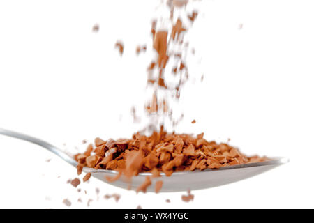 Le chocolat en poudre entrant dans une cuillère contre fond blanc Banque D'Images