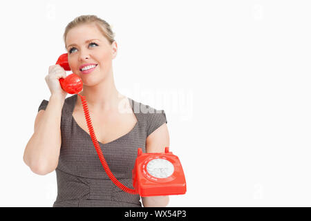 Femme appelant avec quelqu'un à le téléphone contre fond blanc Banque D'Images