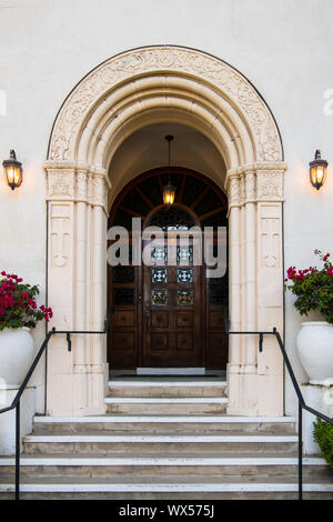 Entrée avec voûte ornée de feux lumineux dans une architecture coloniale Espagnole Bâtiment de style Renaissance avec des murs en stuc blanc et porte en bois rustique Banque D'Images