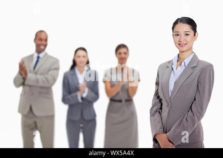 Businesswoman smiling with co-workers smiling et applaudir à l'arrière-plan Banque D'Images