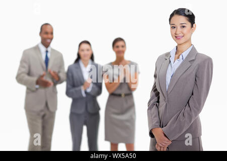 Close-up of a businesswoman smiling with co-workers pour applaudir et la regardant dans l'arrière-plan Banque D'Images