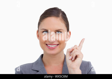 Close up of smiling tradeswoman pointant vers le haut sur un fond blanc. Banque D'Images