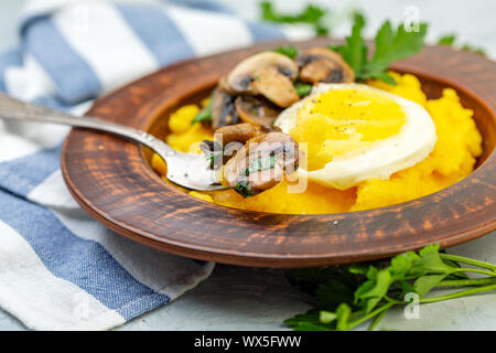 Polenta avec champignons délicieux et l'oeuf. Banque D'Images
