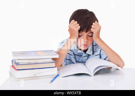 Garçon ses leçons d'apprentissage axé sur un fond blanc. Banque D'Images