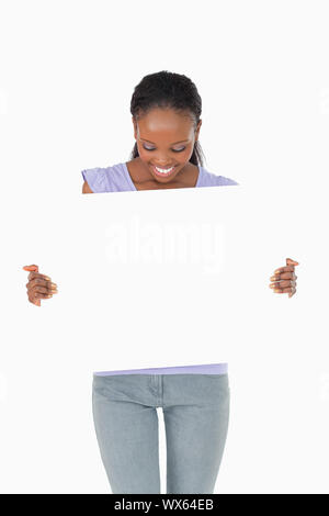 Close up of smiling woman looking at espace réservé dans ses mains sur fond blanc Banque D'Images